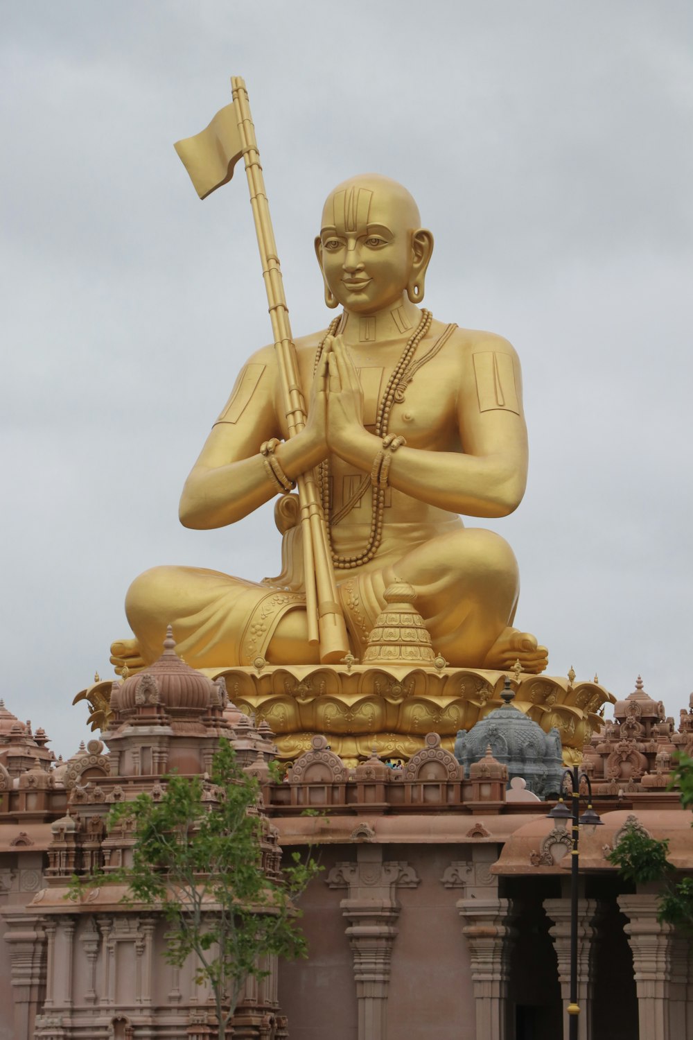 a golden statue of a person holding a flag