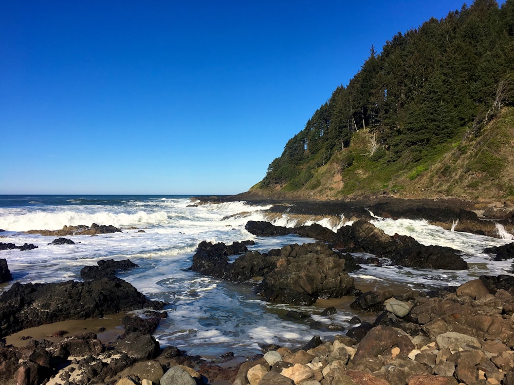 a rocky beach with waves crashing on the rocks