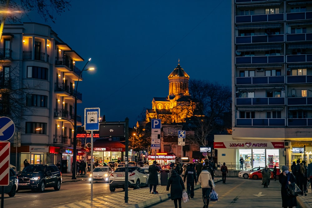 a group of people walking down a street next to tall buildings