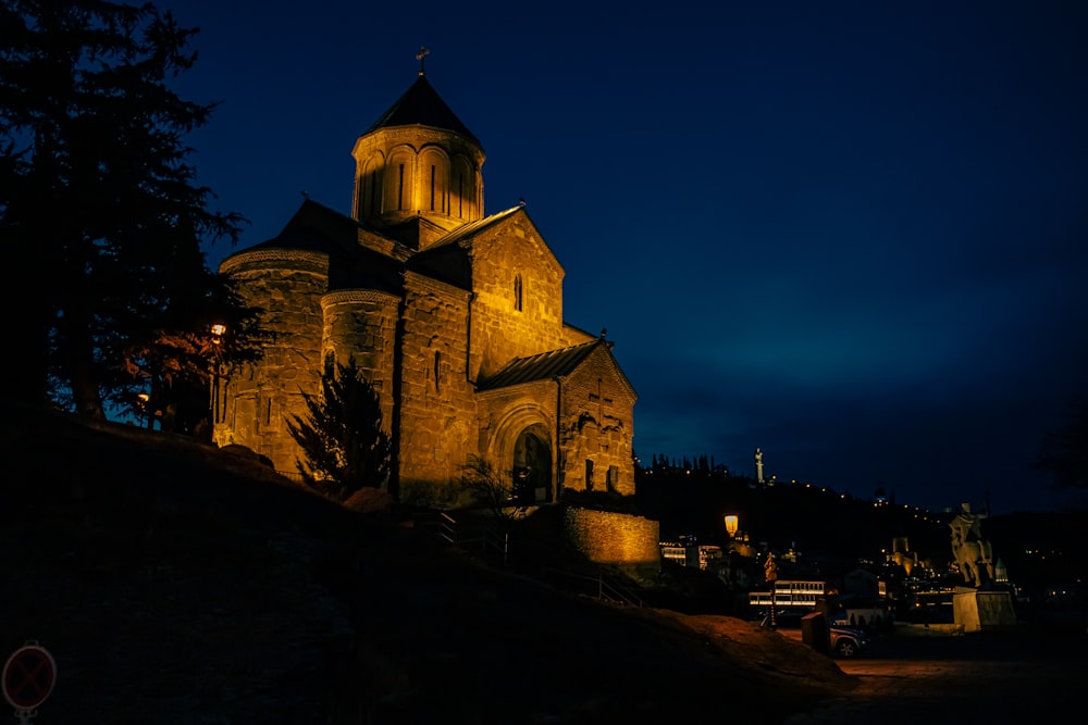 a church lit up at night with a dark sky