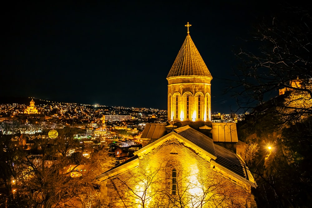 a church with a steeple lit up at night