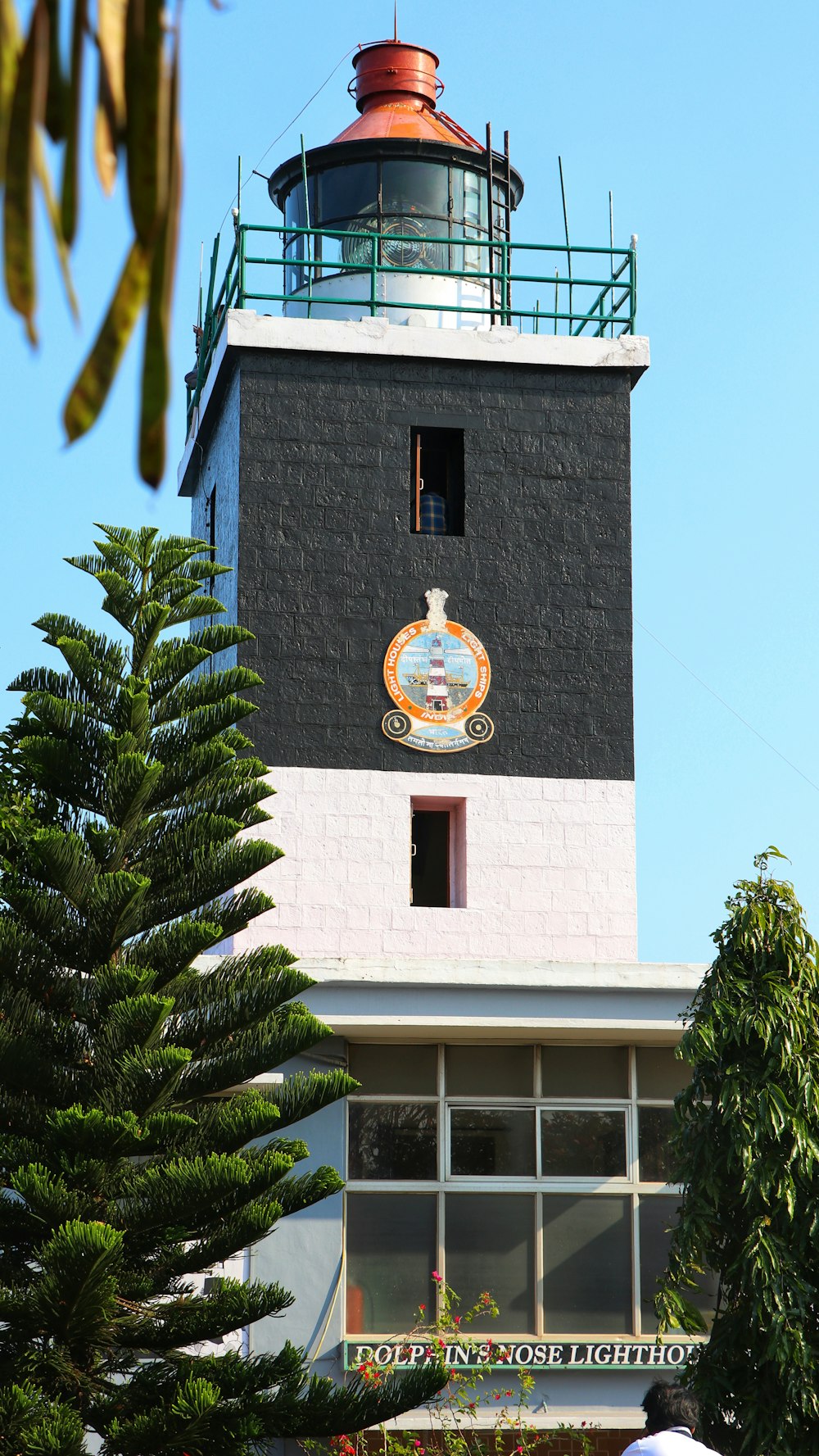 um farol preto e branco com um topo vermelho