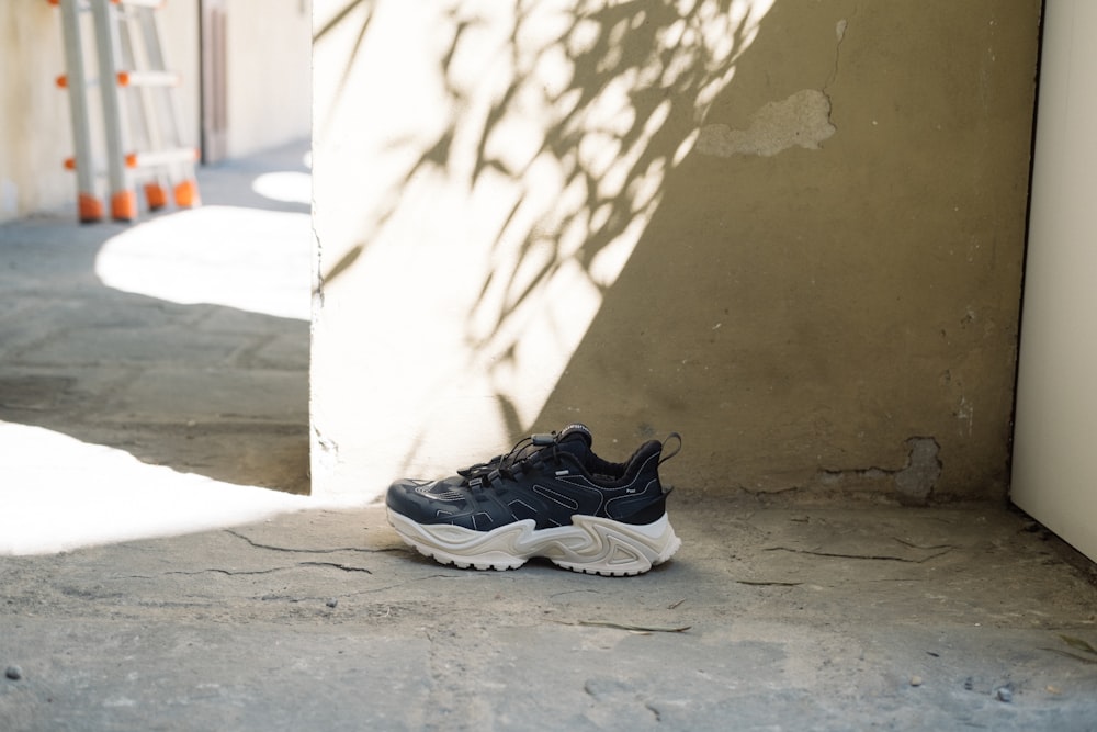 a black and white sneaker sitting on the ground