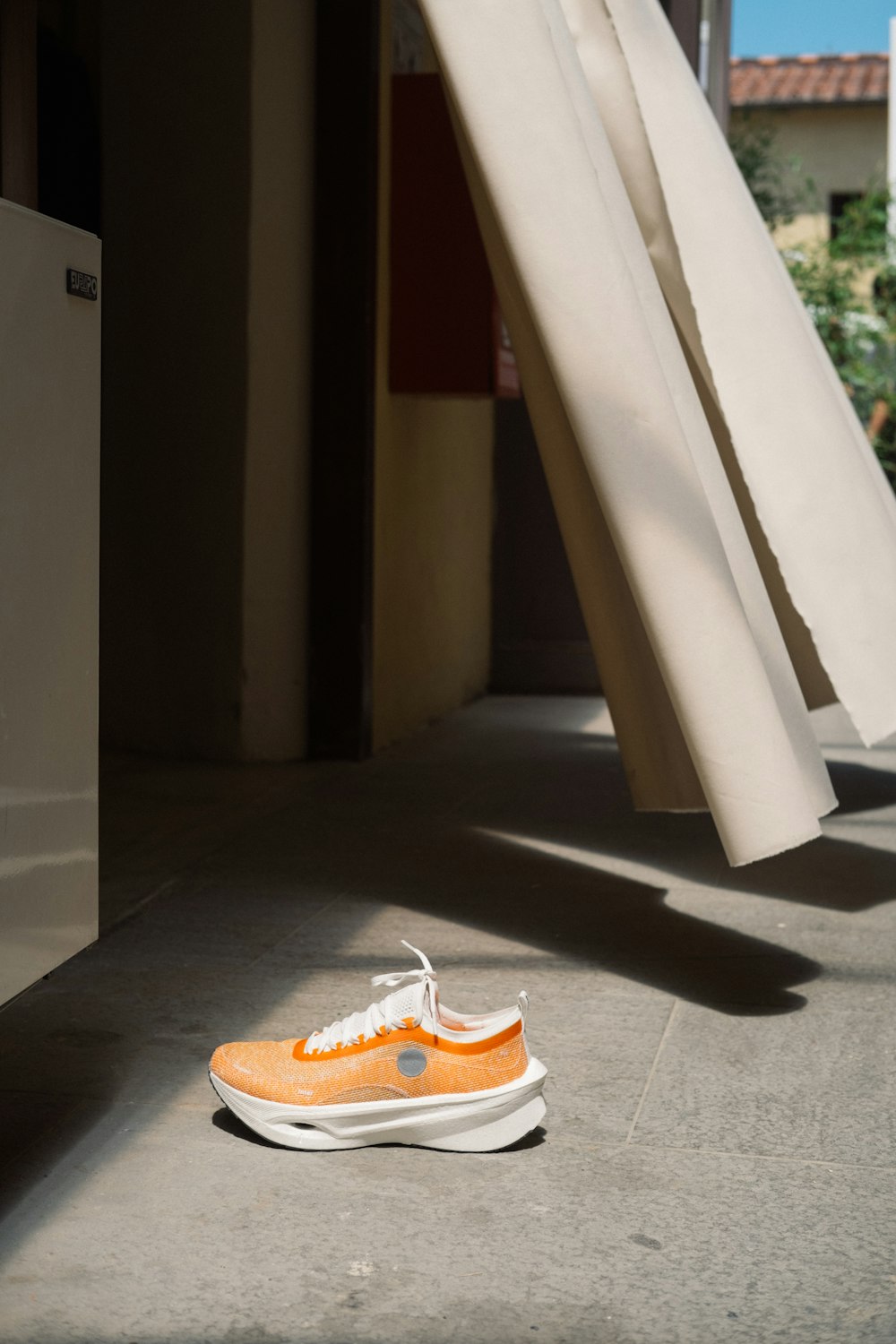 a pair of orange and white shoes sitting on the ground