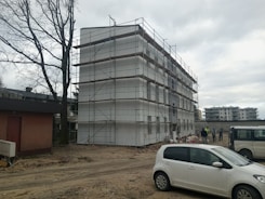 a white car parked in front of a building under construction