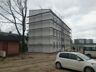 a white car parked in front of a building under construction