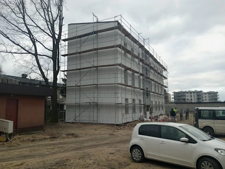 a white car parked in front of a building under construction