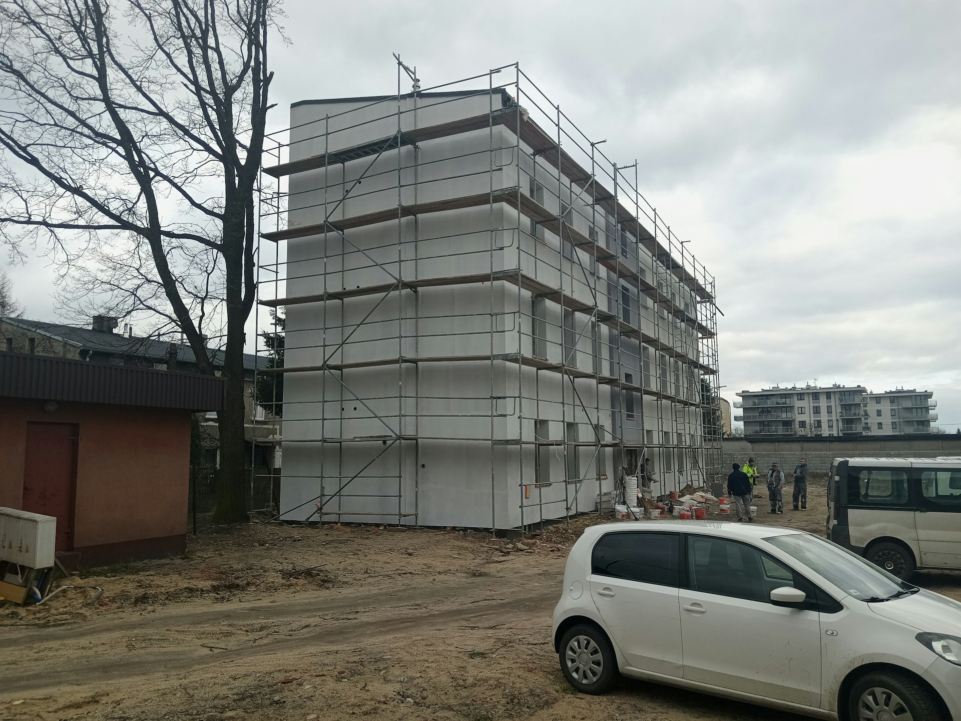 a white car parked in front of a building under construction