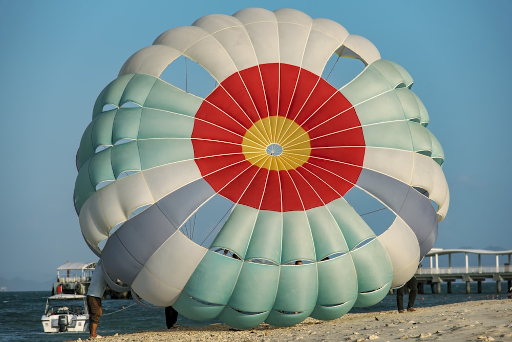 a large kite is on the beach near the water