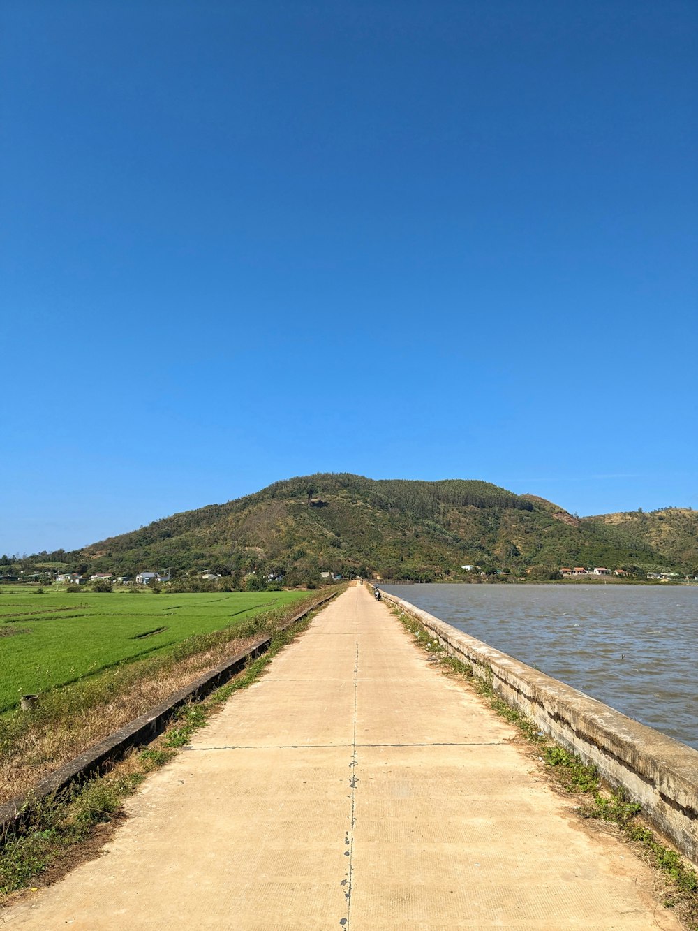 a view of a long road next to a body of water