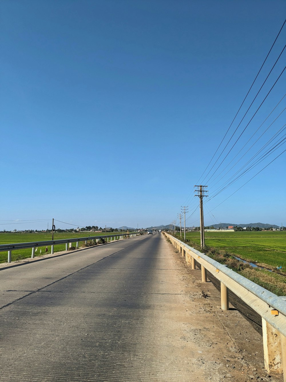 an empty road with power lines above it