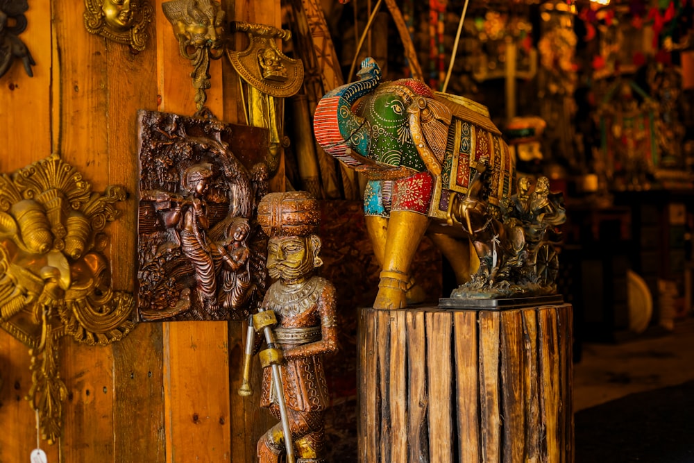 an elephant statue sitting on top of a wooden stump