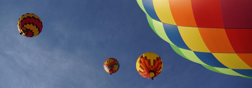 a group of hot air balloons flying through a blue sky