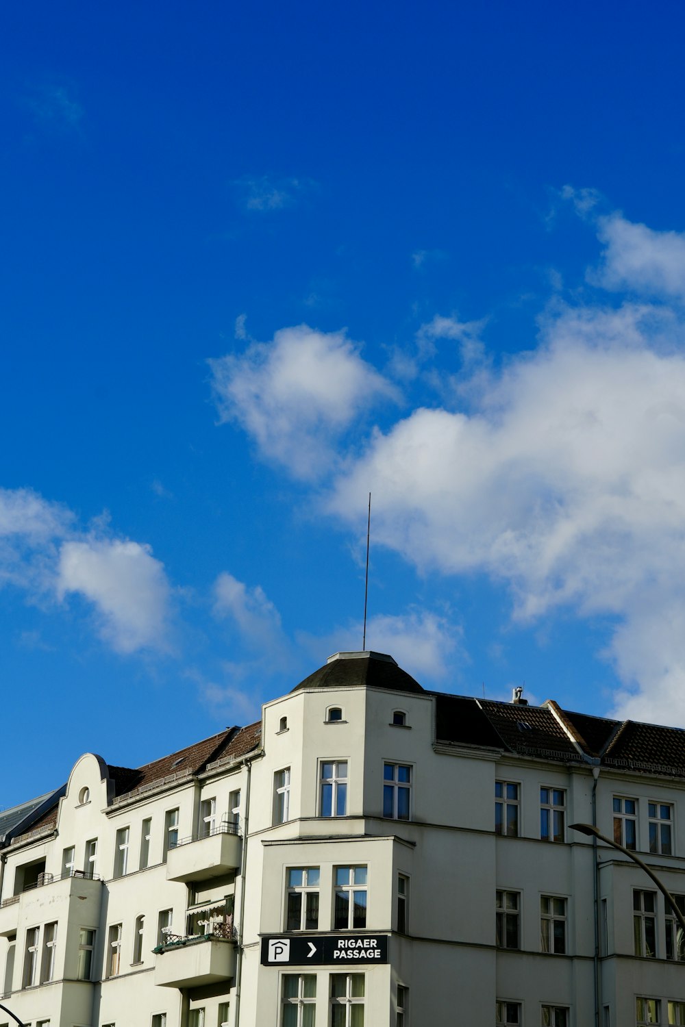 a tall white building sitting next to a traffic light