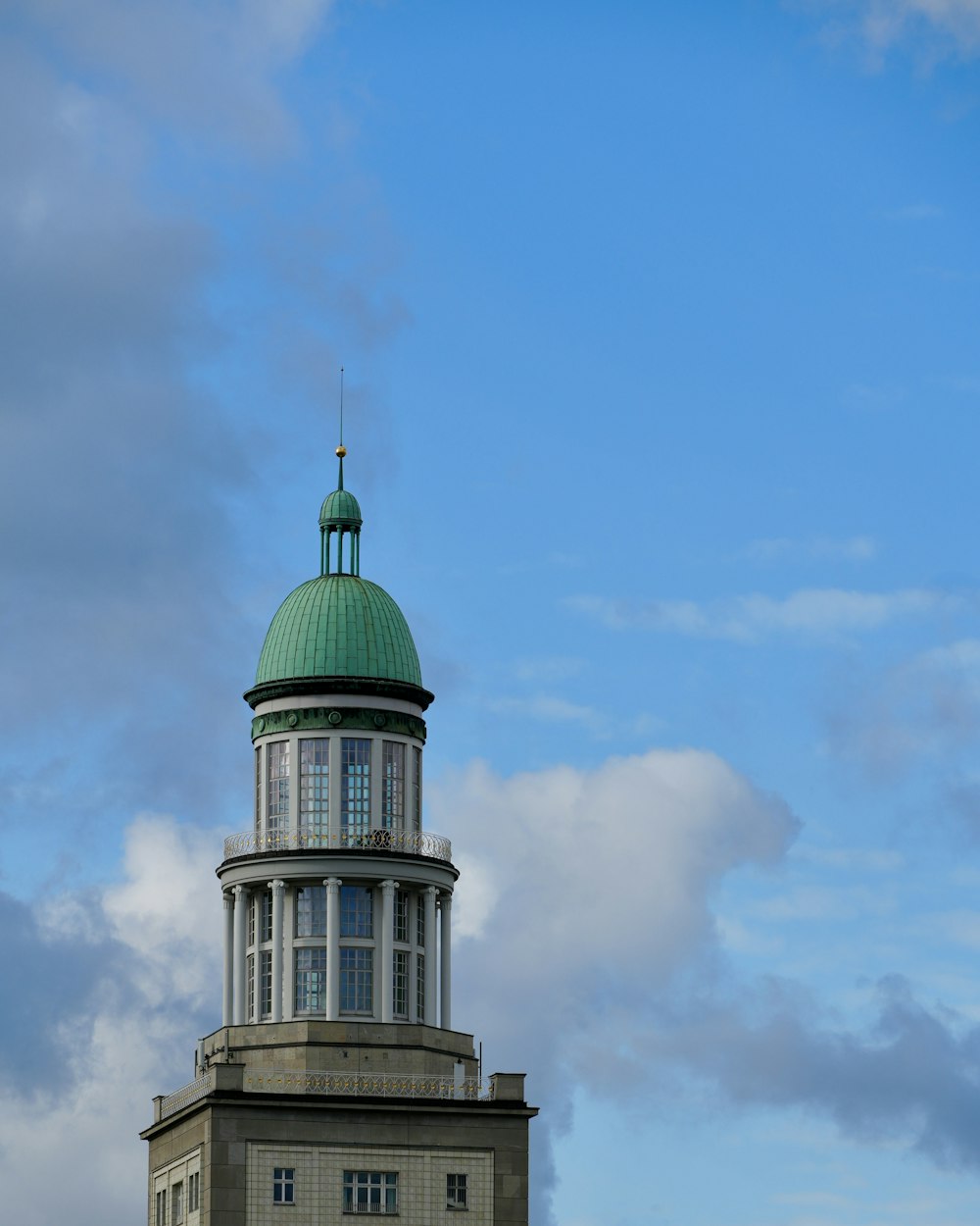 a tall building with a green dome on top