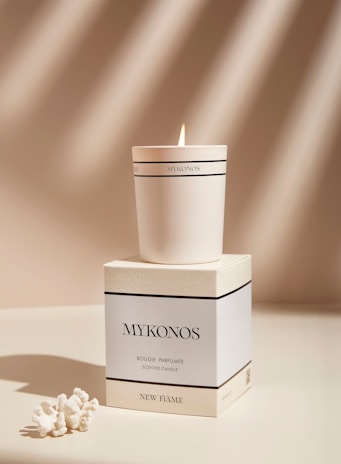 a white candle sitting on top of a box
