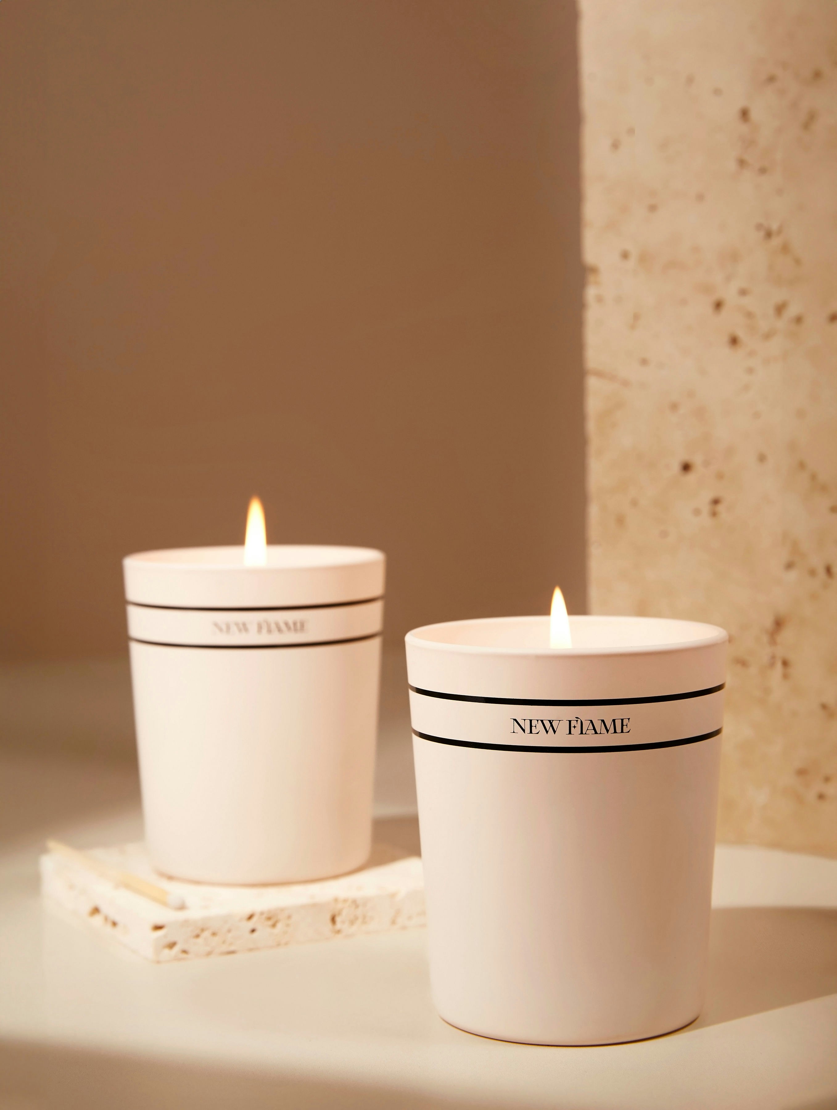 a couple of white candles sitting on top of a table
