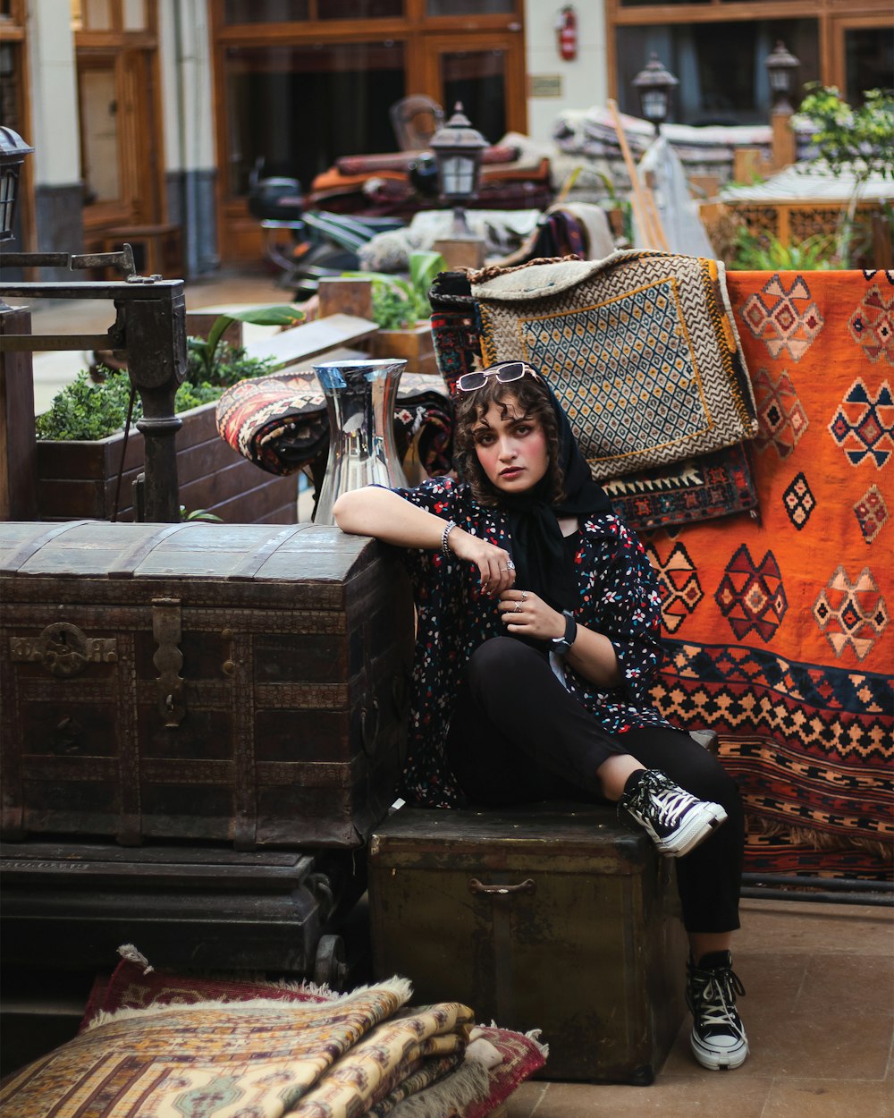 a woman sitting on a trunk in a store