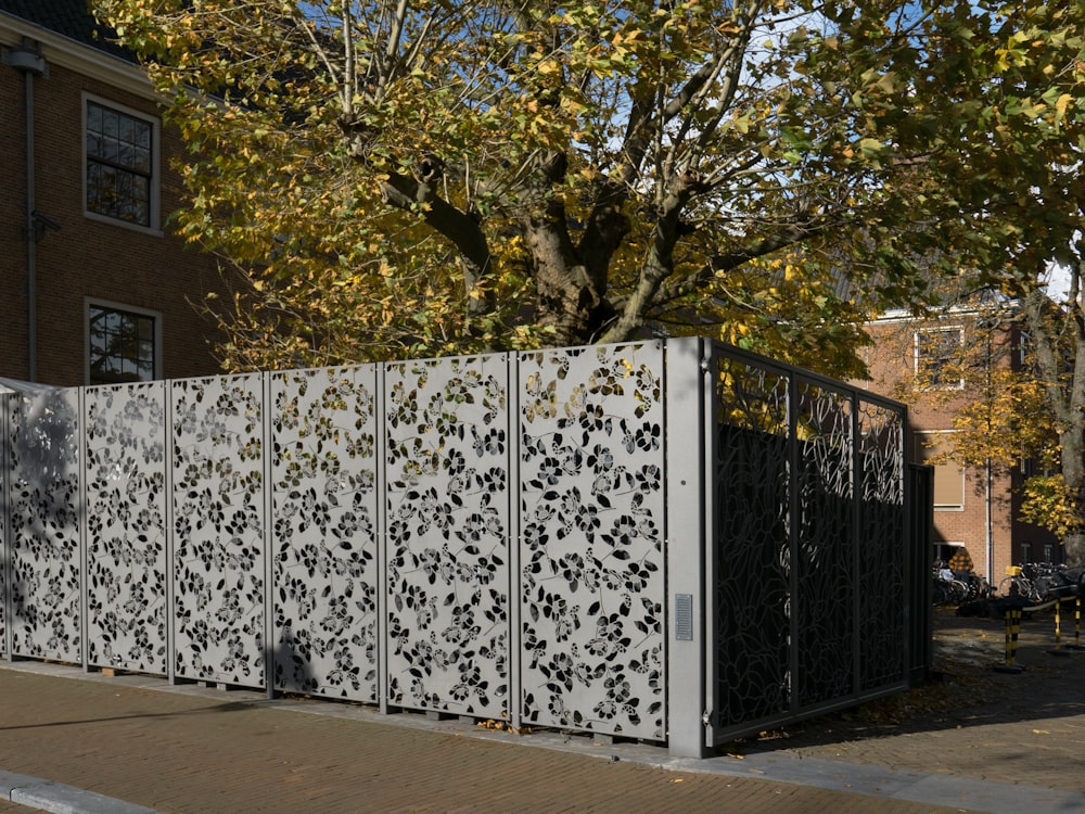 a tall metal fence sitting next to a tree