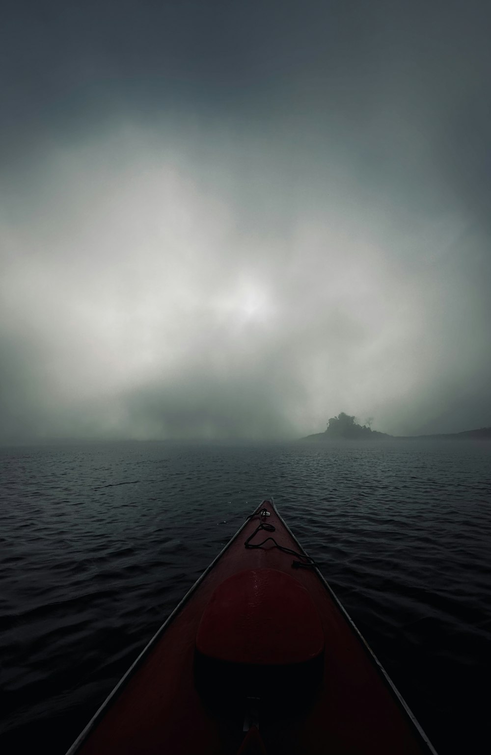 a red kayak in the middle of a body of water