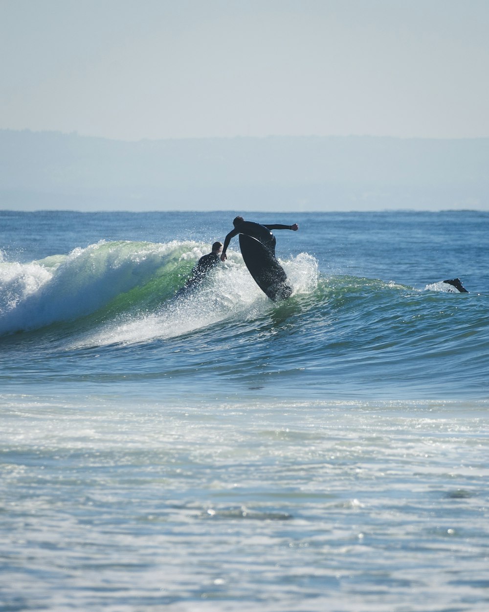 a man riding a wave on top of a surfboard