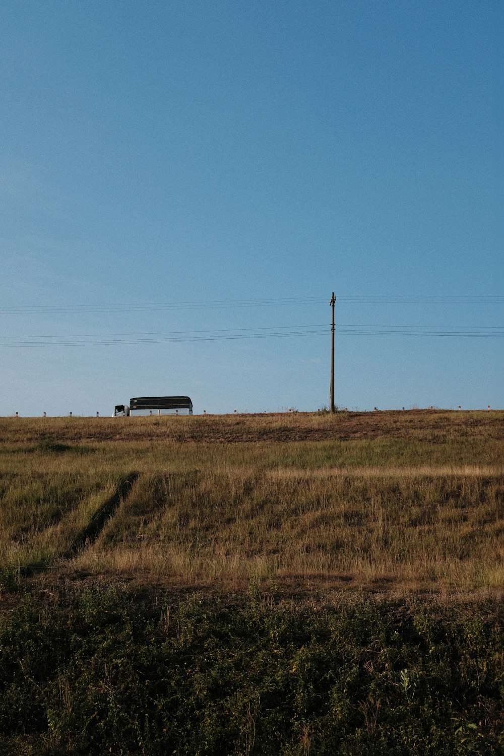 a field with a house in the distance