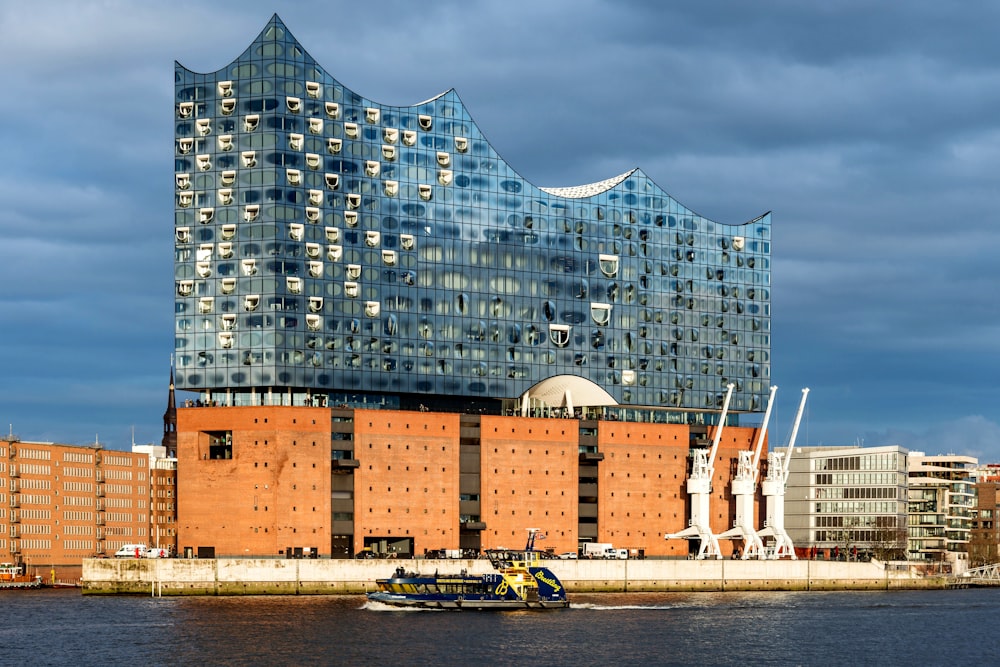 a boat in the water in front of a tall building