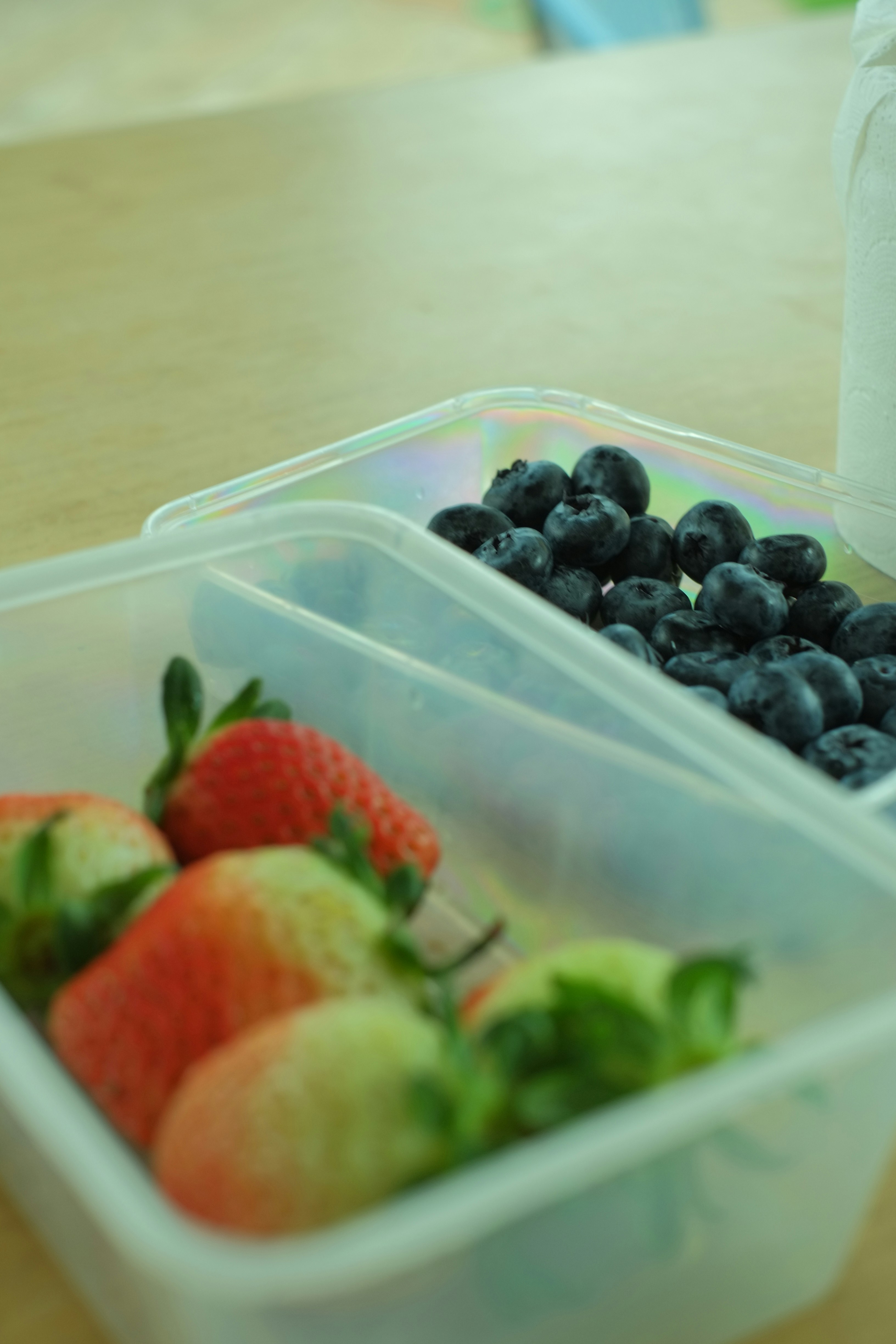 Fresh mixed summer berries in wooden containers, dewy and vibrant in morning light