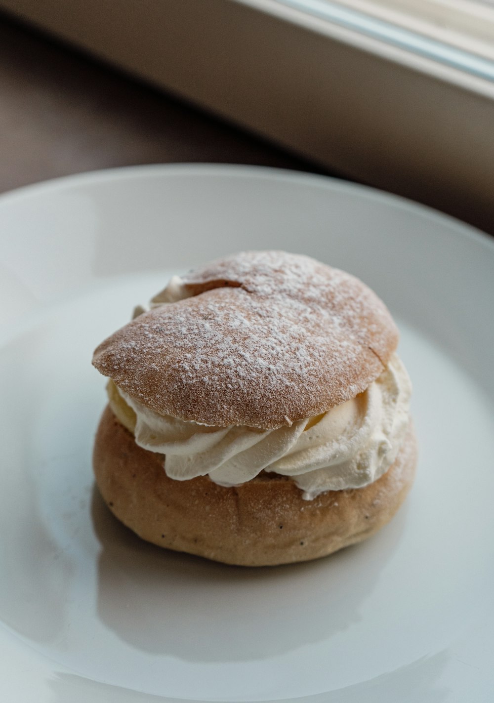 a white plate topped with a pastry covered in cream
