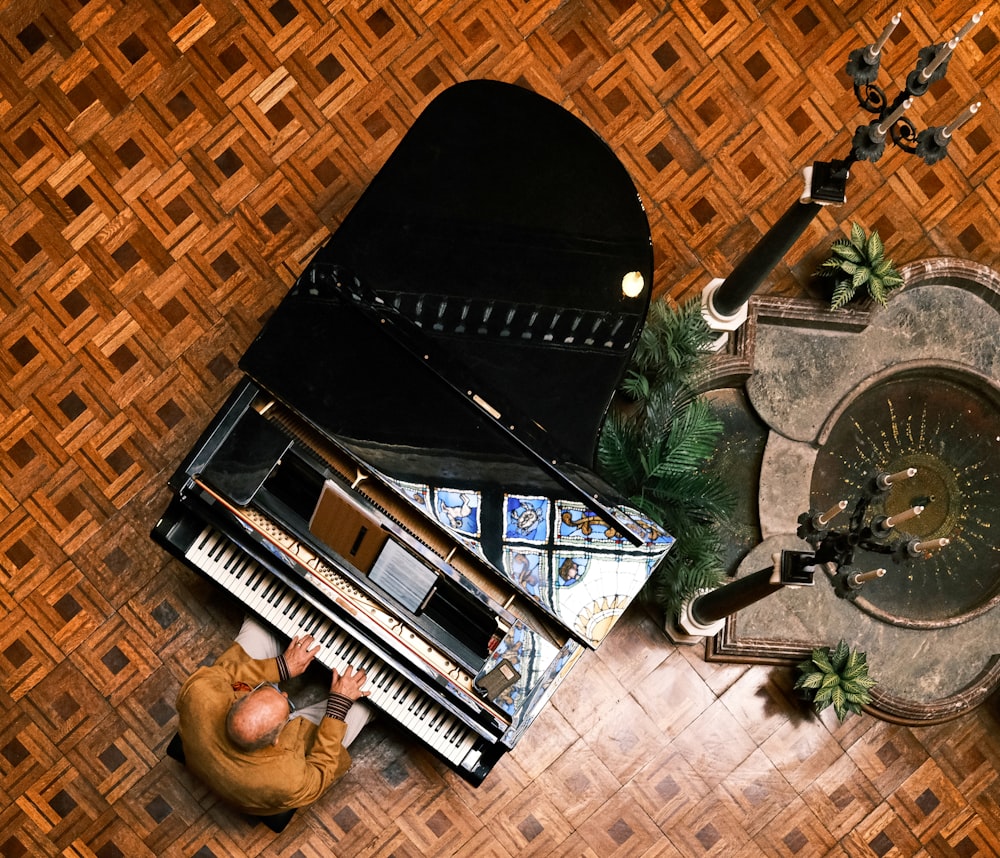 a man sitting on the floor next to a piano