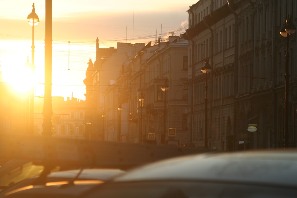 the sun is setting on a city street