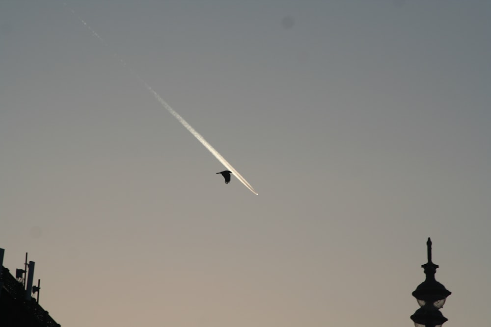 a jet flying in the sky over a building