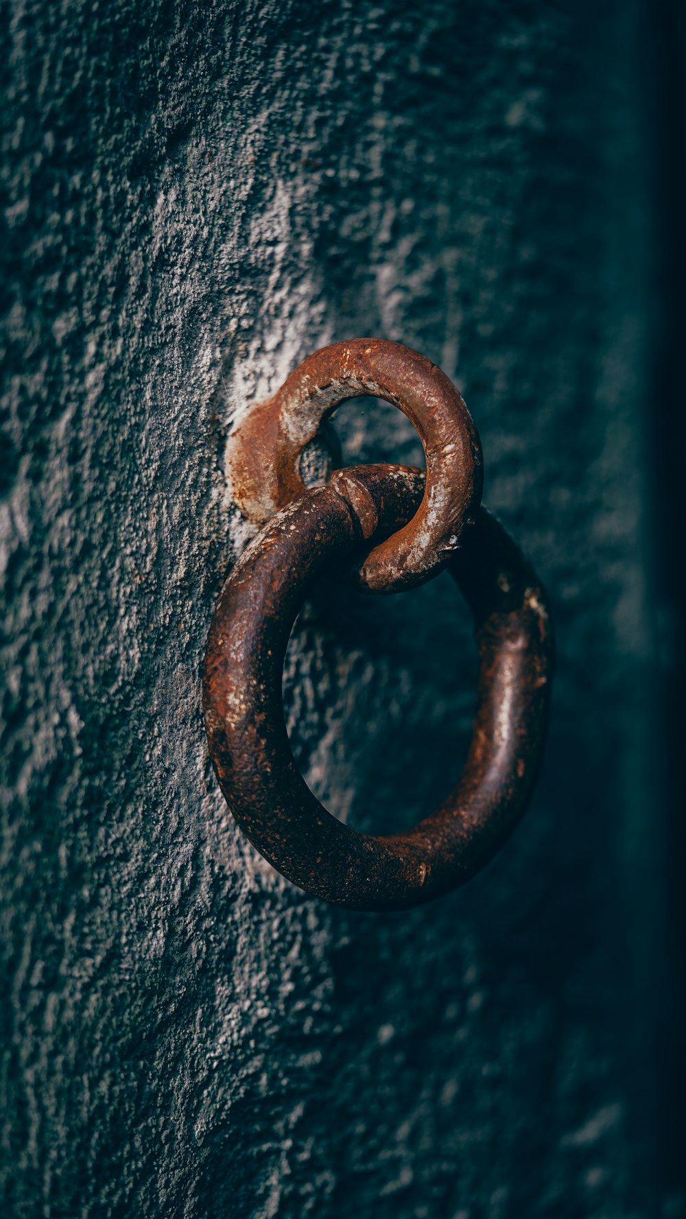 a rusted metal ring on the side of a wall