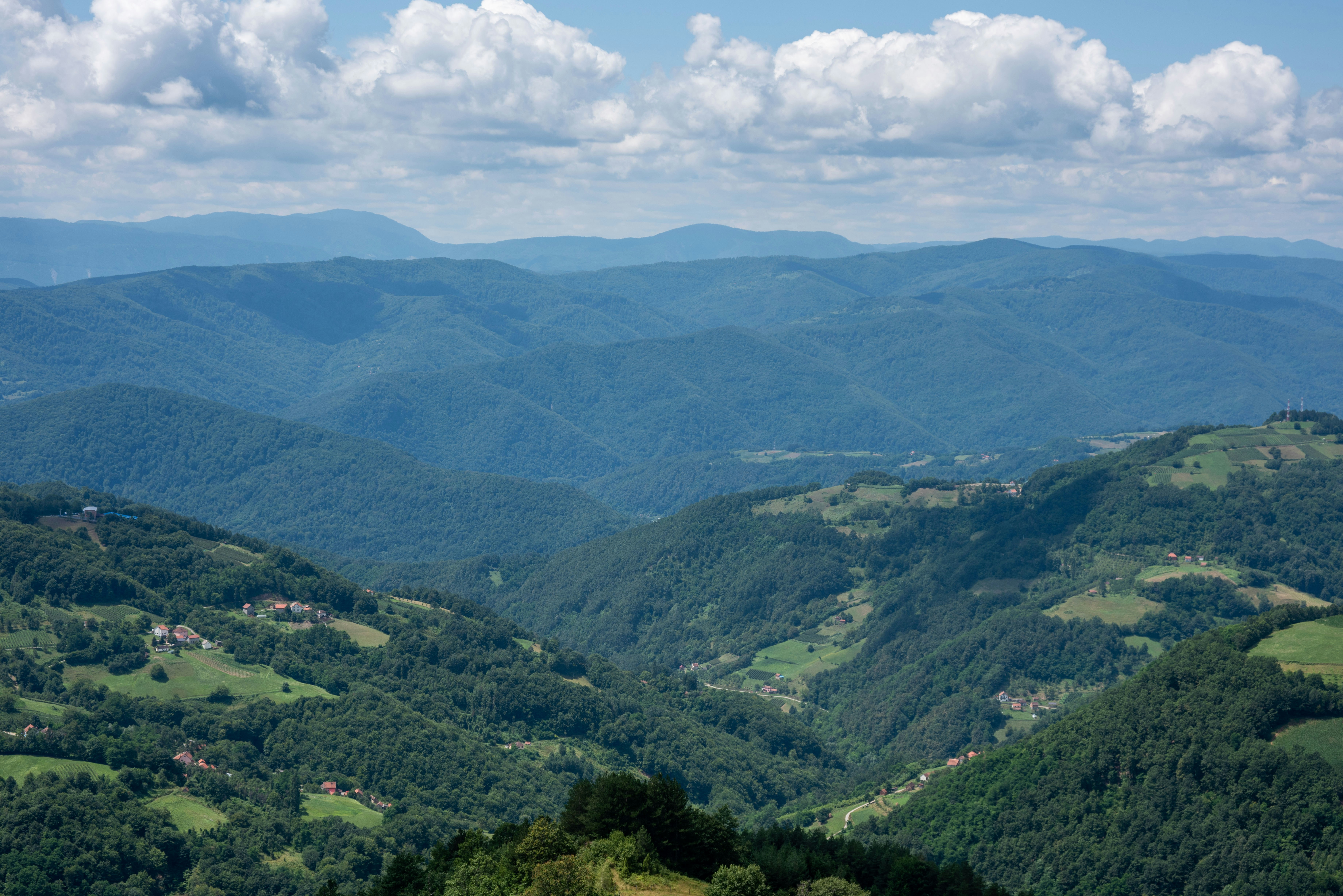 a scenic view of a valley with mountains in the background