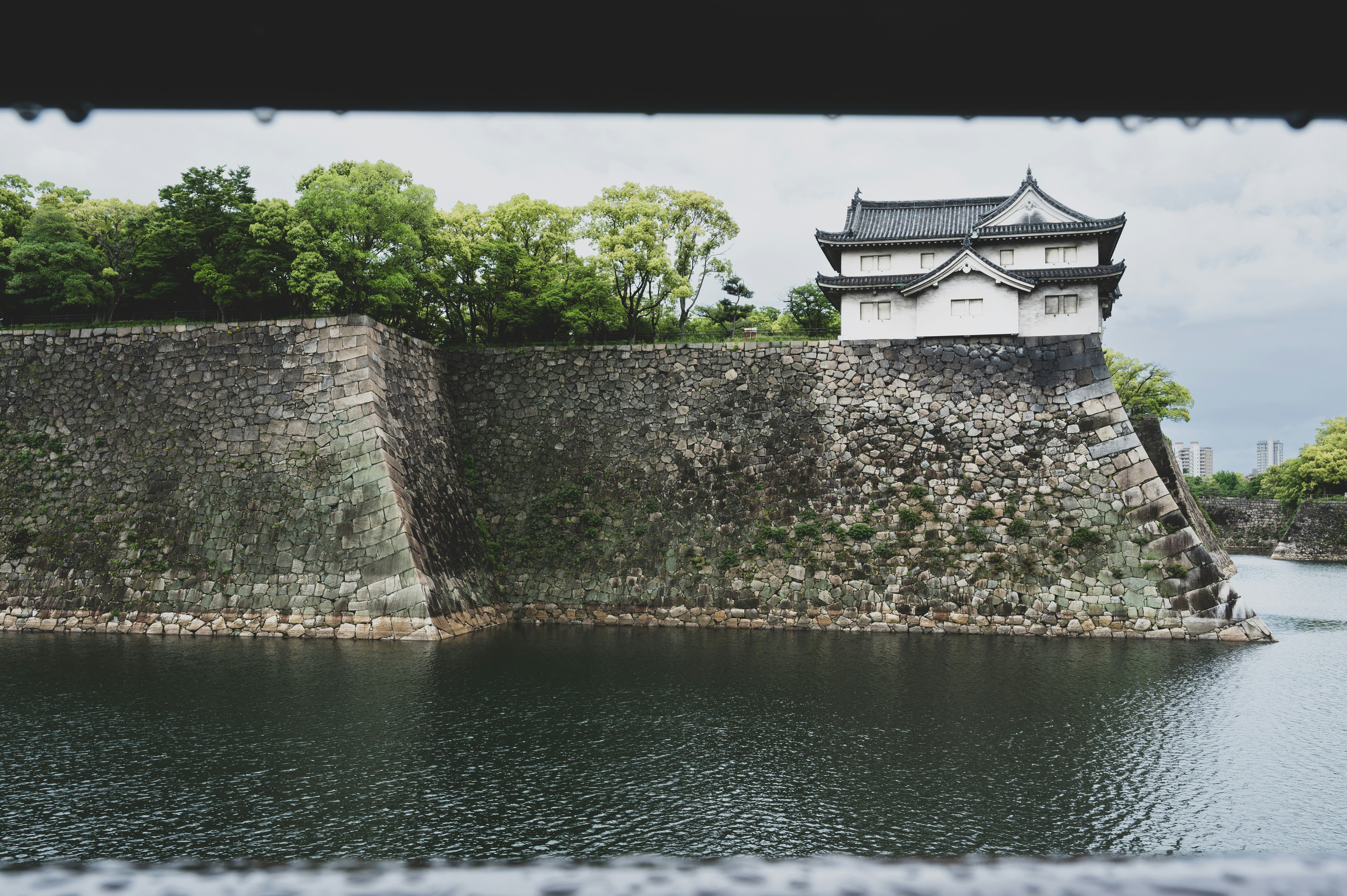 a castle on top of a rock wall next to a body of water
