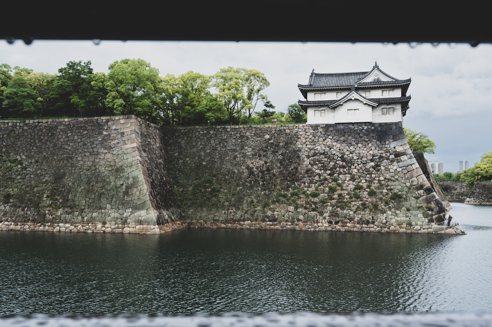 a castle on top of a rock wall next to a body of water