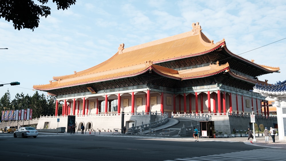 a tall building with a red roof on a street corner