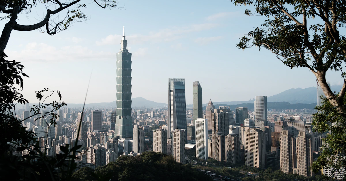 Professional working at desk with Taiwan city view, resume and job search interface visible