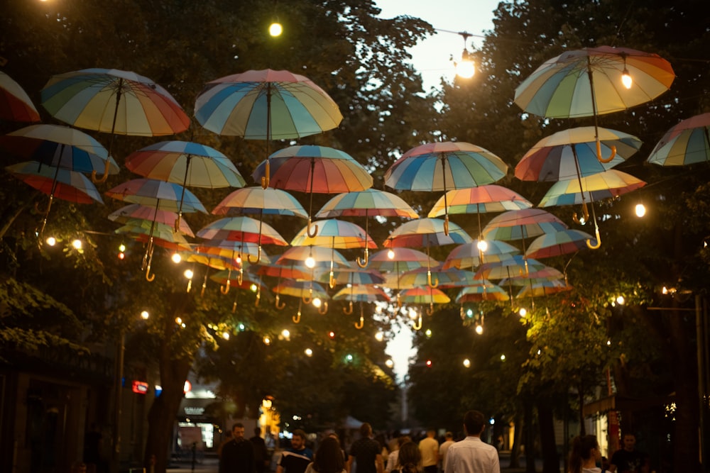 a group of people walking down a street under umbrellas