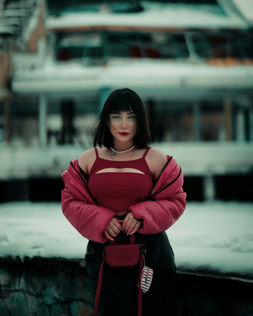 a woman standing in front of a boat in the snow