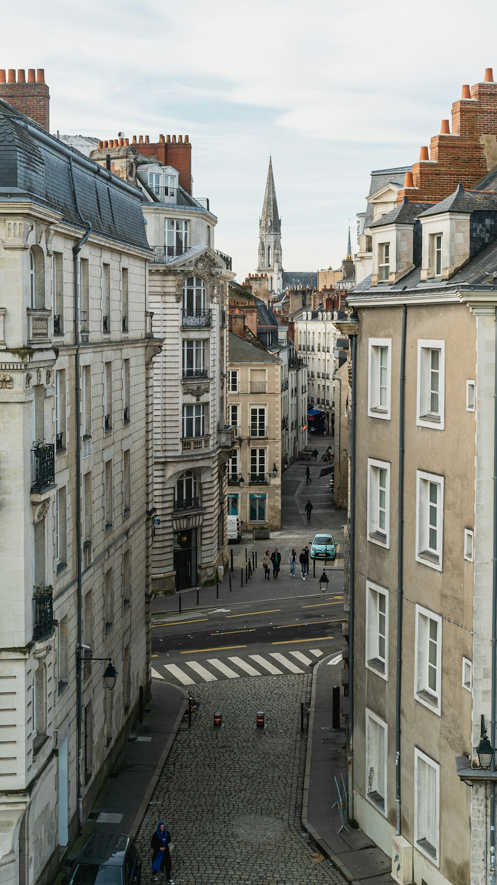 a city street with buildings and a clock tower in the background