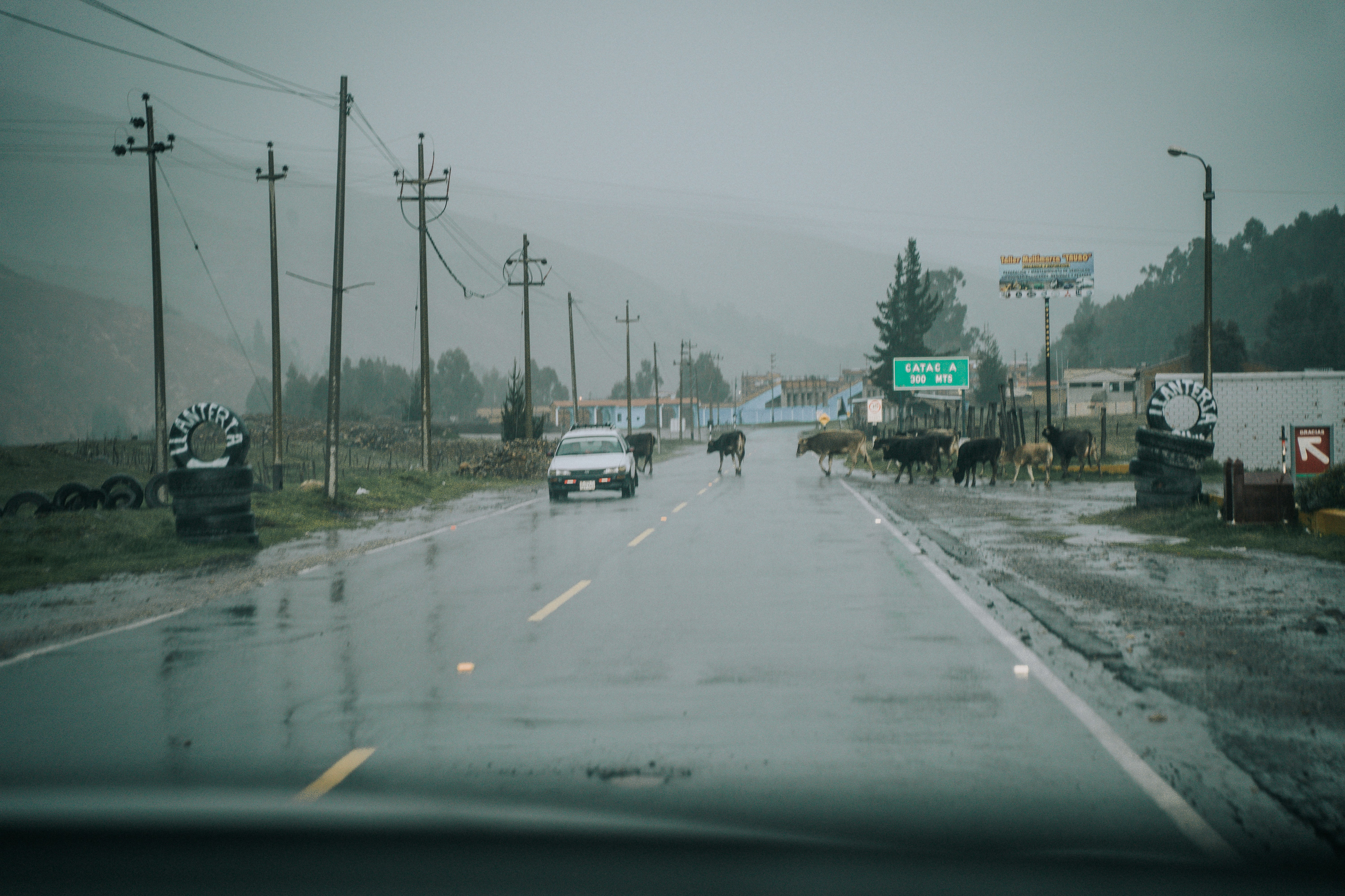 a car driving down a rain soaked road