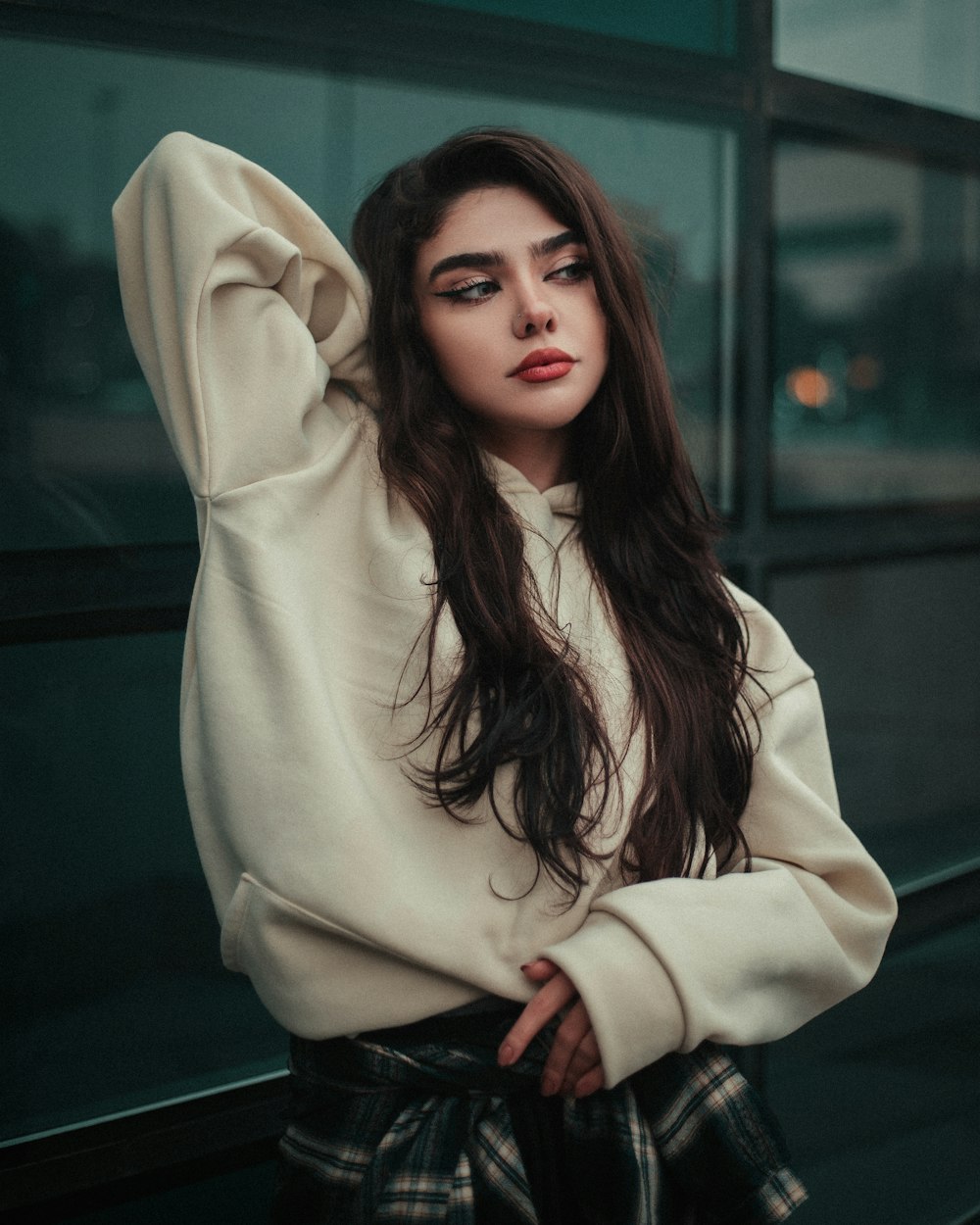 a woman with long hair wearing a white sweater