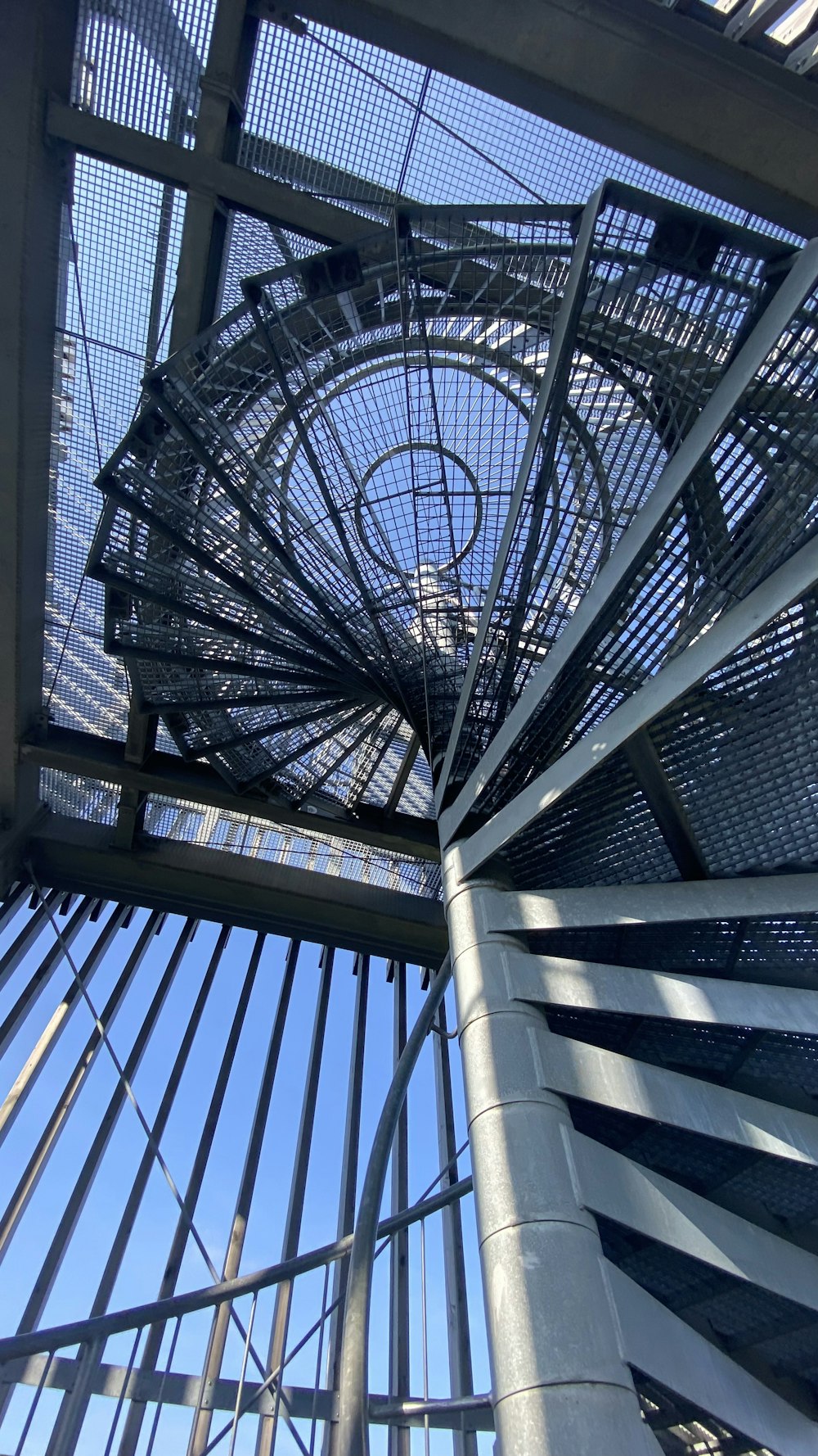 a spiral staircase in a building with a blue sky in the background
