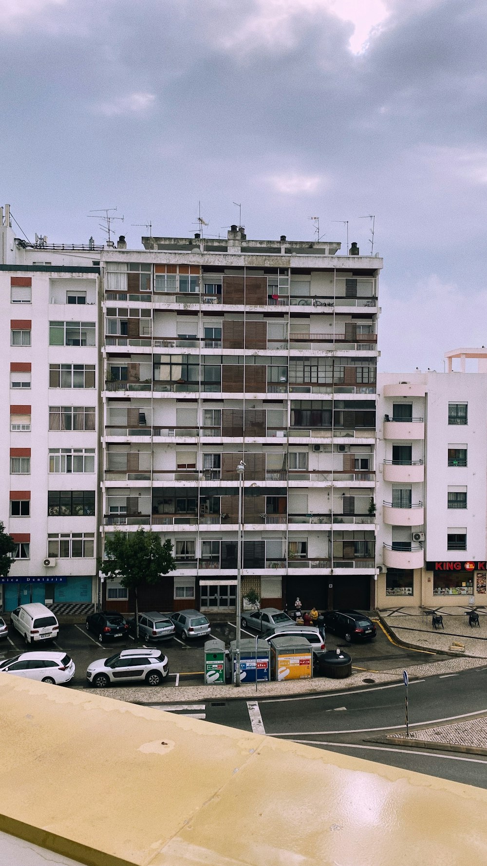 a very tall building sitting next to a parking lot