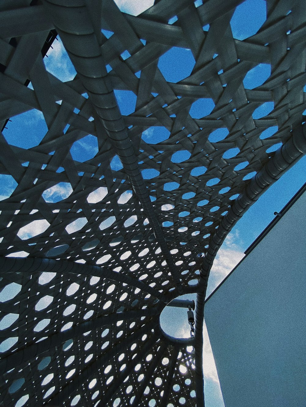 a close up of a metal structure with a sky in the background