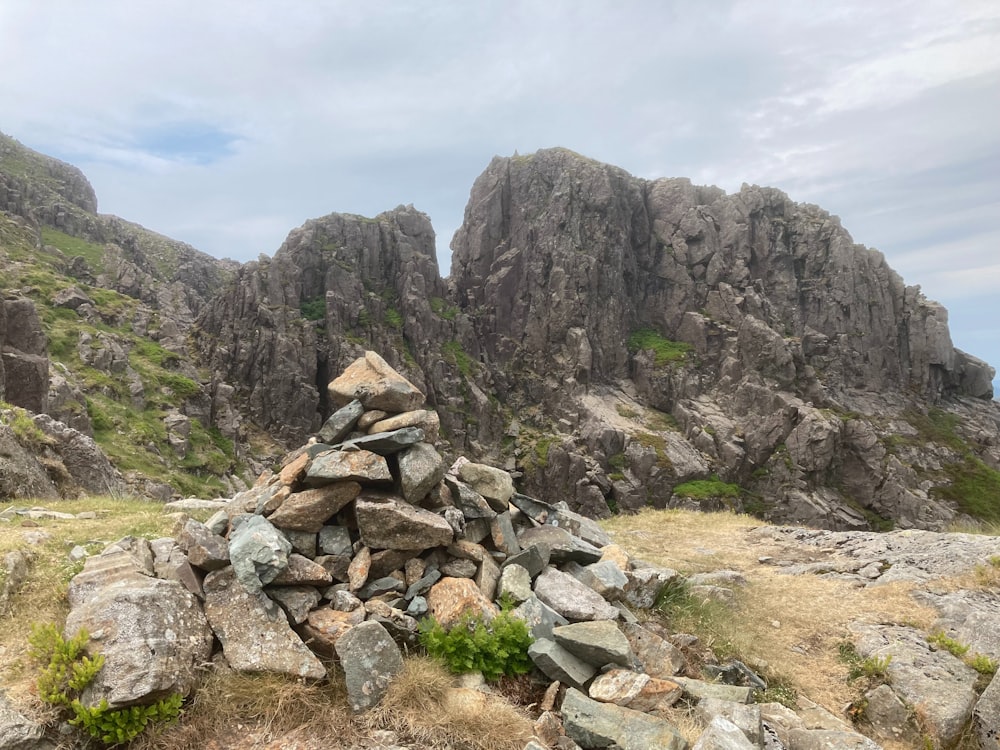 a pile of rocks sitting on top of a grass covered hillside