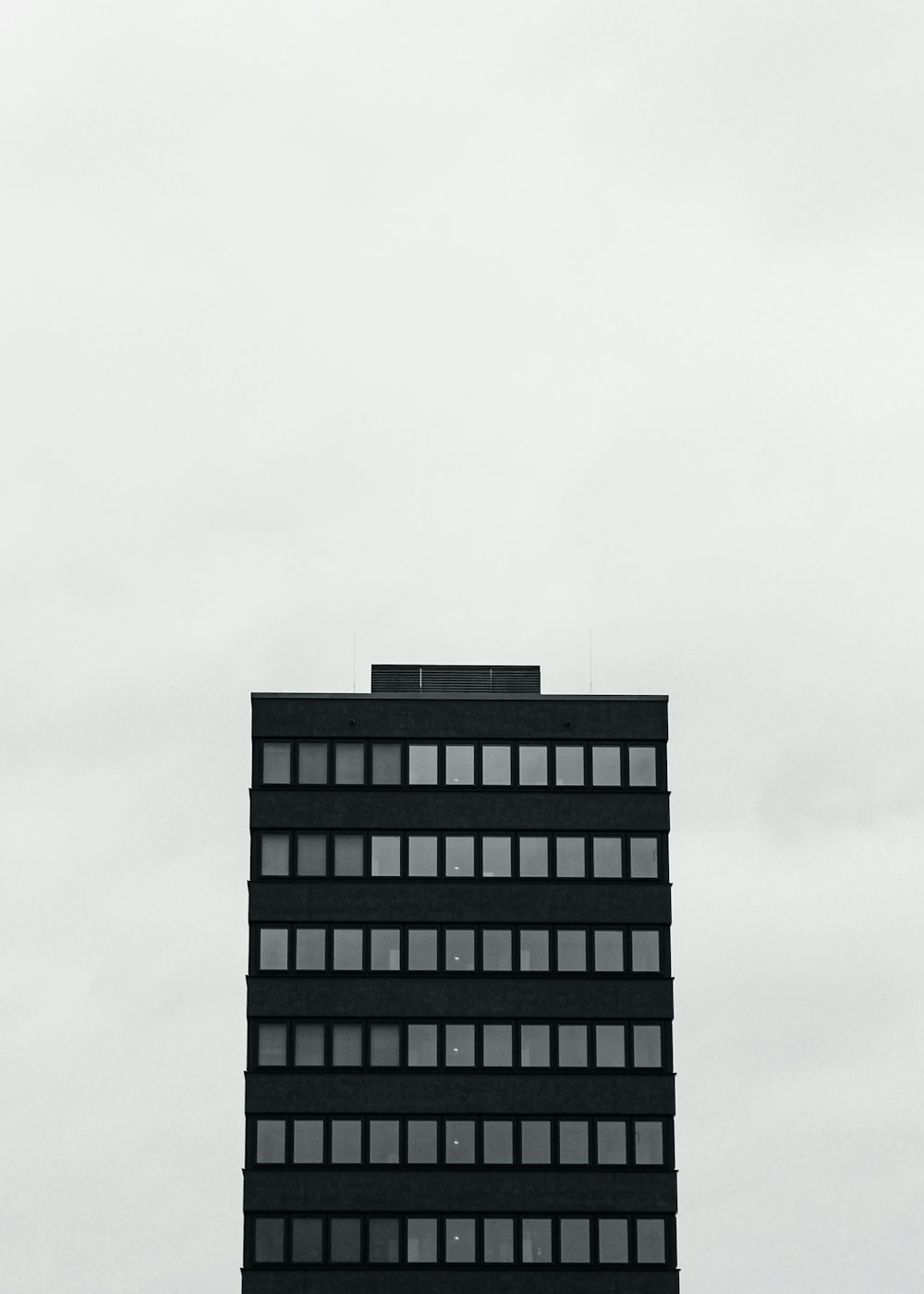 an airplane flying in the sky over a tall building