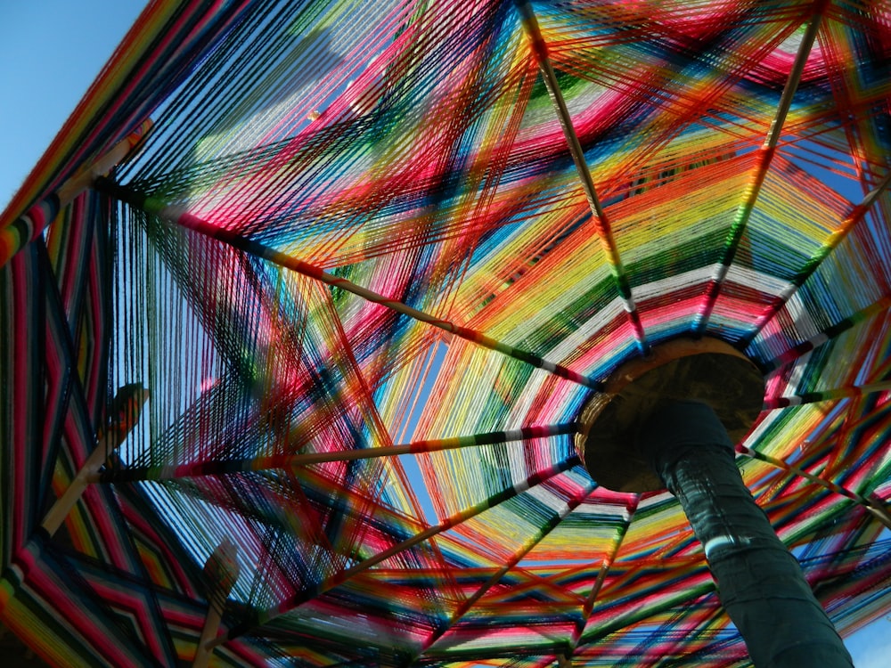 a multicolored umbrella with a blue sky in the background