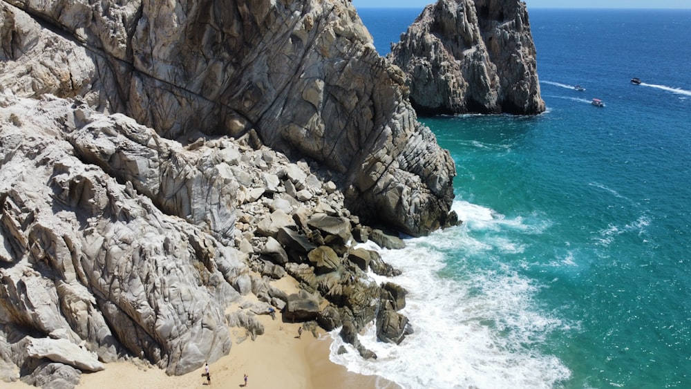 a boat is in the water near some rocks